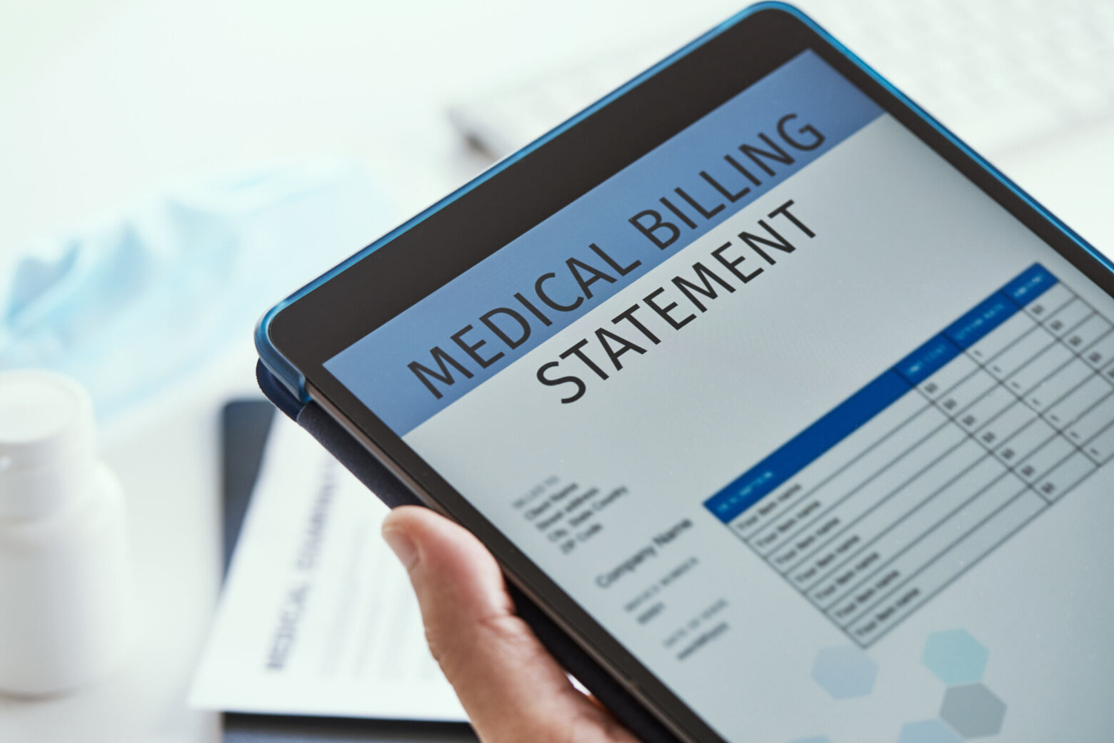 closeup of a caucasian doctor man, sitting at his office desk, checking a medical billing statement in a digital tablet